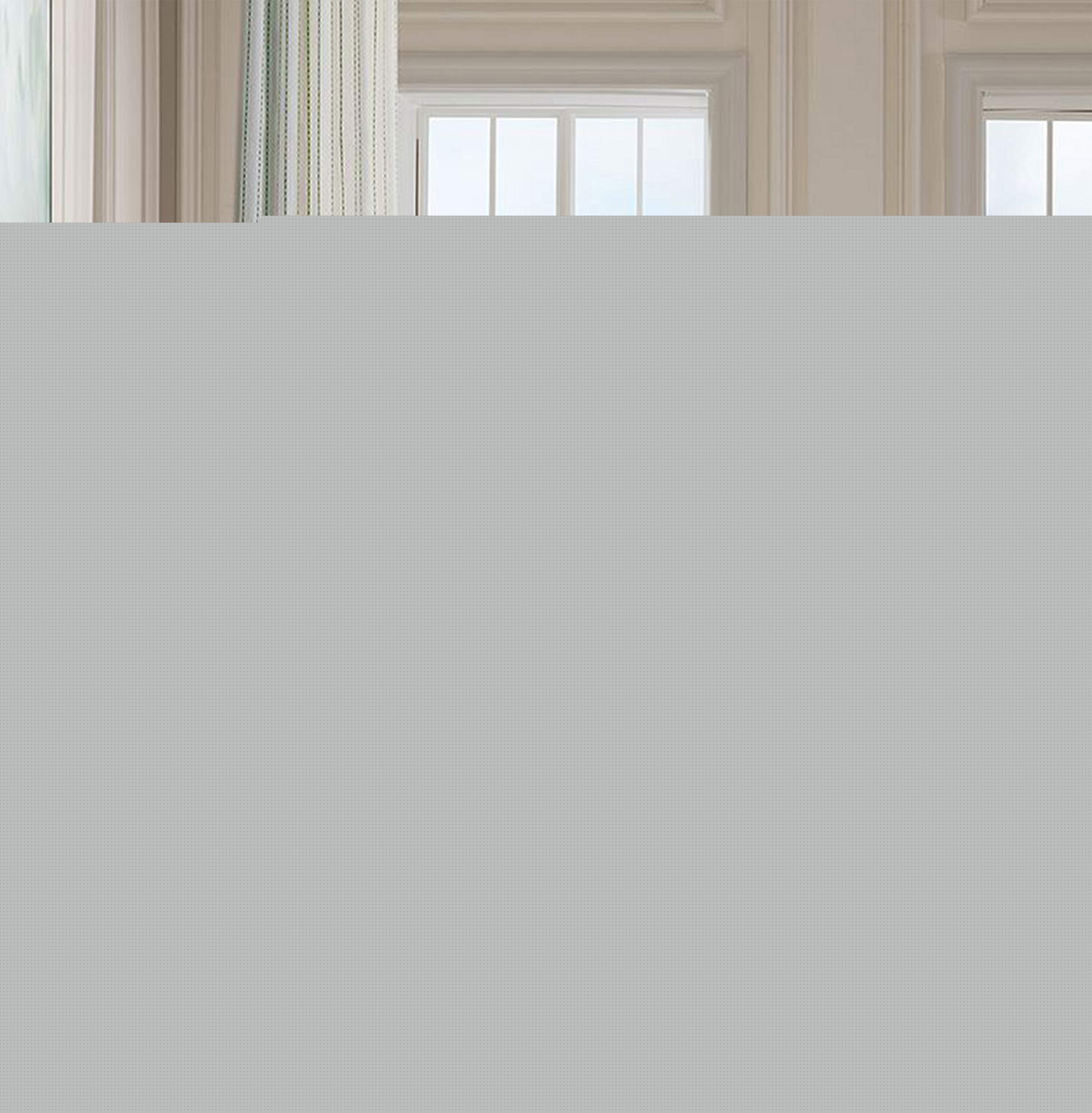 A large solid gray rectangular block obscures most of the frame, with only a small sliver of an interior room scene visible at the top edge including cream walls, molding, and a window.